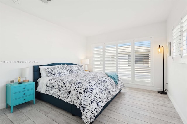 bedroom featuring baseboards and wood finished floors