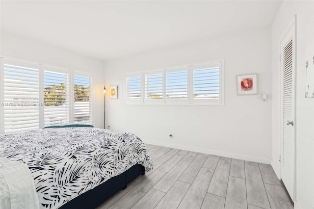 bedroom with access to exterior, wood tiled floor, and baseboards