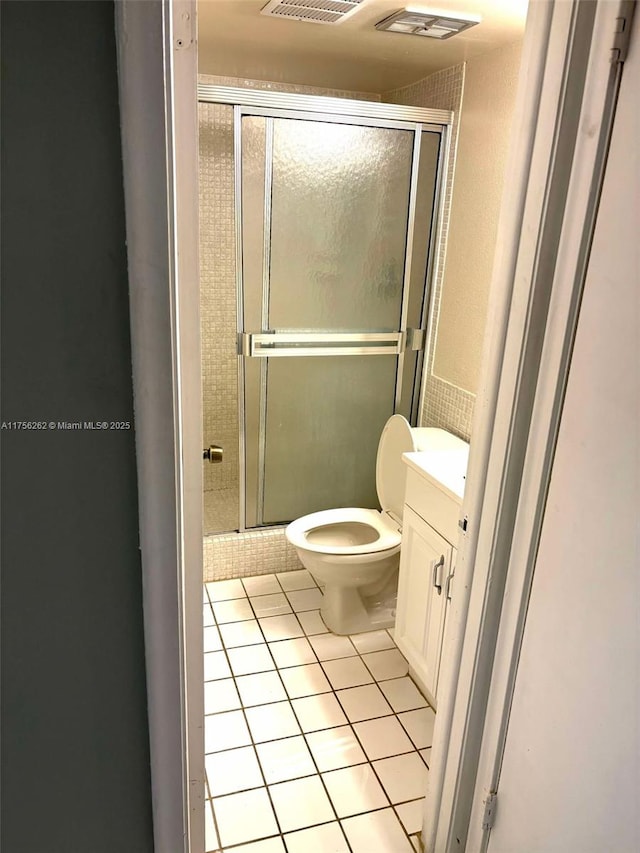 full bathroom featuring visible vents, toilet, tile patterned floors, vanity, and a shower stall