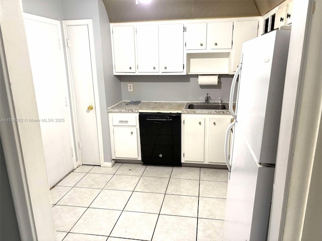 kitchen featuring freestanding refrigerator, dishwasher, a sink, and light tile patterned floors