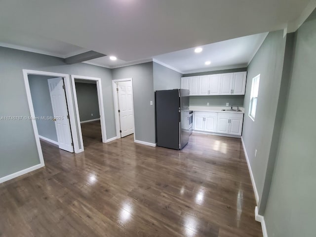 kitchen featuring freestanding refrigerator, dark wood-style flooring, white cabinets, and baseboards