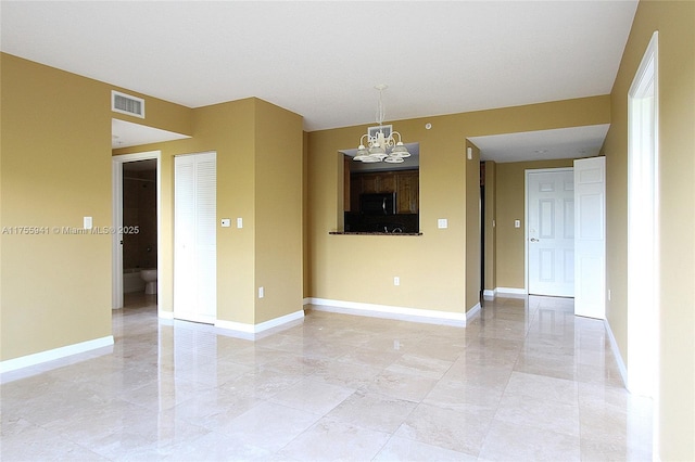 unfurnished room with baseboards, visible vents, and a notable chandelier