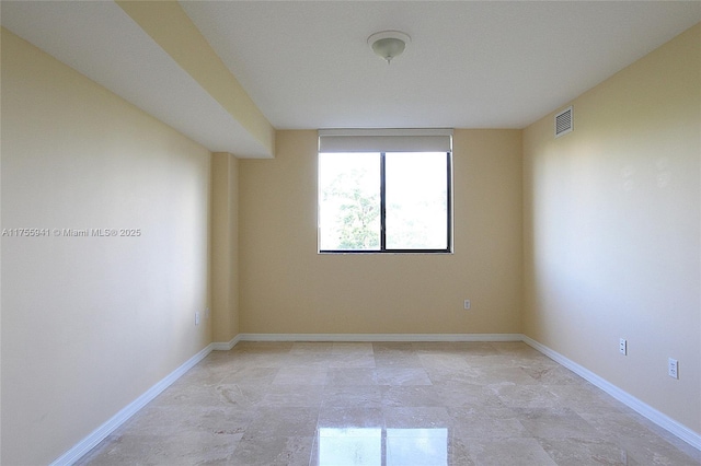 empty room with baseboards and visible vents