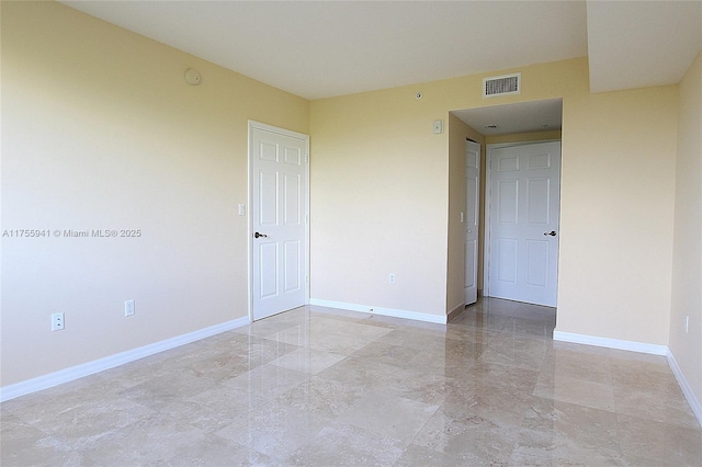 unfurnished room featuring marble finish floor, visible vents, and baseboards