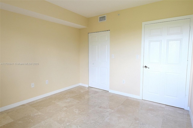 unfurnished bedroom featuring visible vents and baseboards