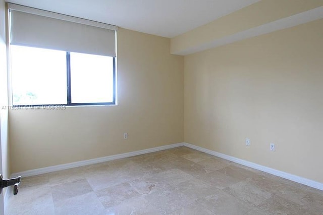 unfurnished room featuring baseboards