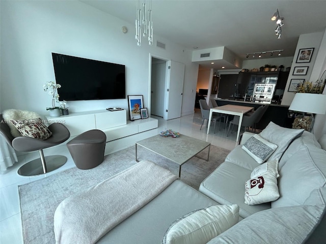 living area featuring rail lighting, visible vents, and tile patterned floors