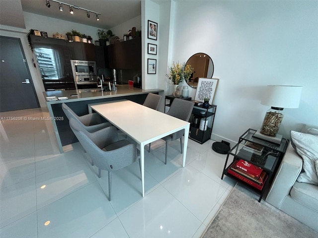 dining space featuring rail lighting and light tile patterned floors