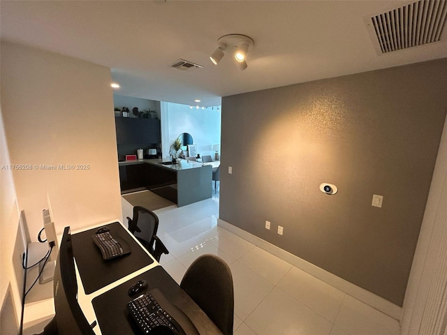 office with baseboards, visible vents, a sink, and light tile patterned flooring