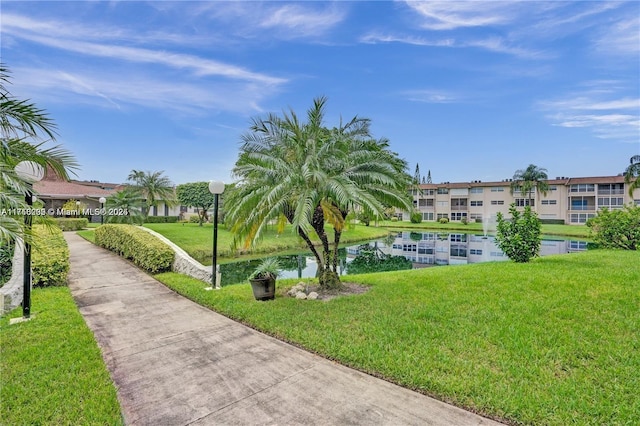 view of home's community with a water view and a yard