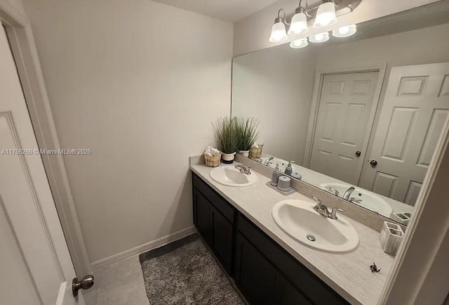 full bathroom featuring double vanity, baseboards, and a sink