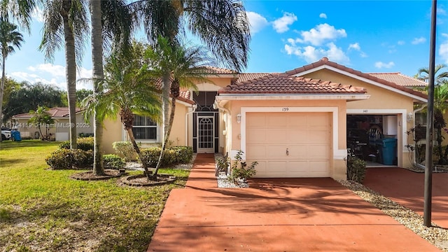 mediterranean / spanish home featuring an attached garage, a tile roof, driveway, stucco siding, and a front lawn