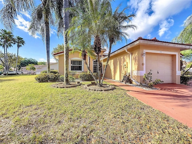 view of front of property with an attached garage, driveway, a front yard, and stucco siding