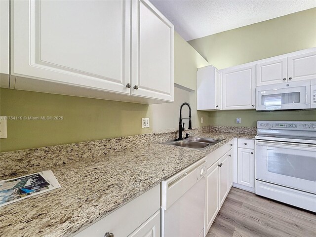 139 Sausalito Dr, Boynton Beach, FL 33436 - kitchen featuring light wood-style flooring, white cabinetry, a sink, light stone countertops, and white appliances