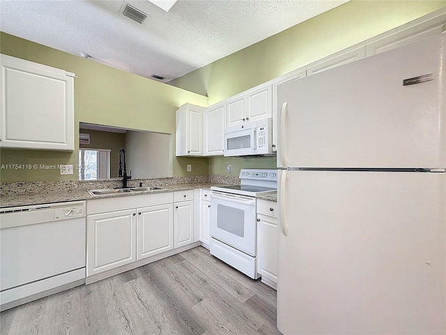 139 Sausalito Dr, Boynton Beach, FL 33436 - kitchen with light wood finished floors, visible vents, white cabinetry, a sink, and white appliances