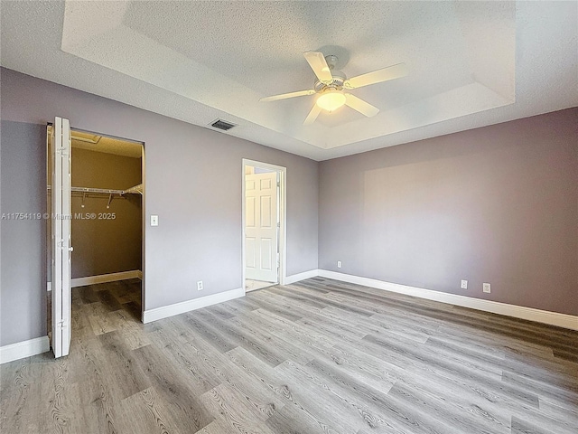 139 Sausalito Dr, Boynton Beach, FL 33436 - unfurnished bedroom with visible vents, a raised ceiling, light wood-style flooring, and baseboards