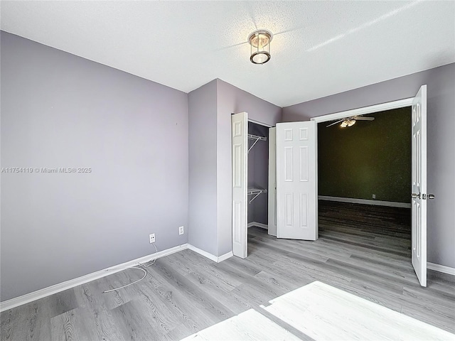 139 Sausalito Dr, Boynton Beach, FL 33436 - unfurnished bedroom featuring a textured ceiling, a closet, wood finished floors, and baseboards