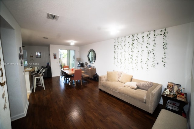 living area with wood finished floors and visible vents