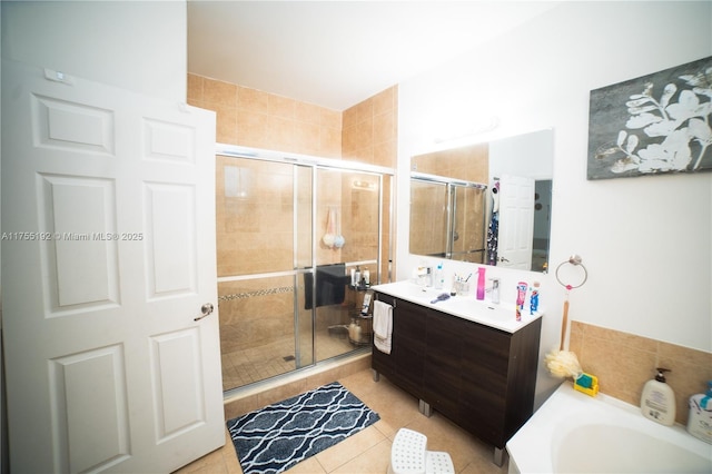 bathroom featuring double vanity, a shower stall, a tub to relax in, and tile patterned floors
