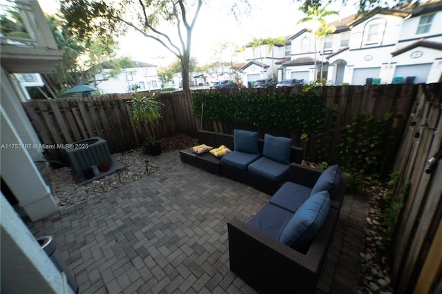 view of patio with central AC unit, outdoor lounge area, a fenced backyard, and a residential view