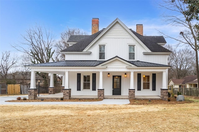 view of front of property with a porch, metal roof, fence, and board and batten siding