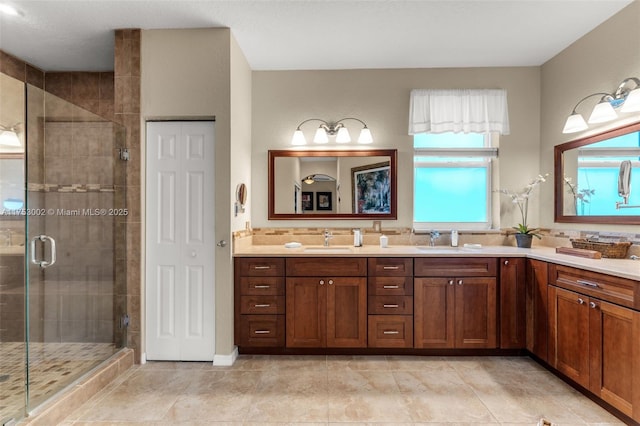 bathroom with a sink, a shower stall, and double vanity