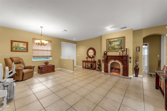 living area featuring light tile patterned floors, visible vents, a fireplace, and arched walkways