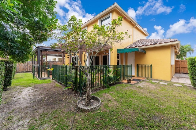 rear view of house with a yard, a fenced backyard, and stucco siding