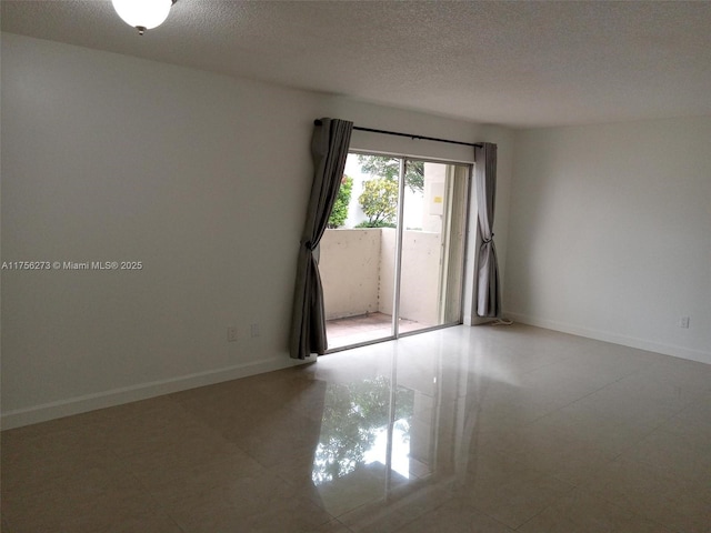 empty room with a textured ceiling and baseboards