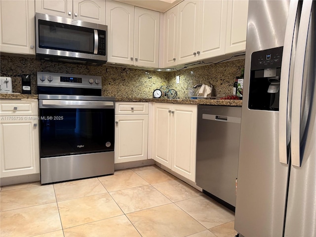 kitchen with light tile patterned floors, appliances with stainless steel finishes, decorative backsplash, and white cabinets