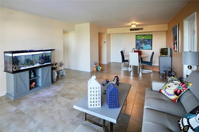 living room with visible vents, baseboards, and light tile patterned floors