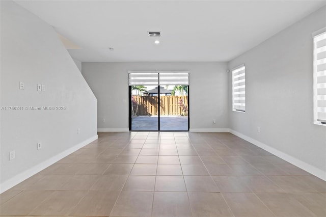 tiled empty room featuring baseboards