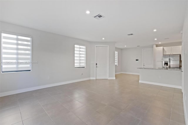 unfurnished living room featuring recessed lighting, visible vents, and baseboards