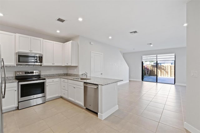 kitchen with light stone countertops, visible vents, appliances with stainless steel finishes, and a sink