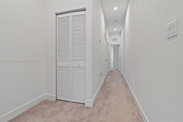 hall featuring recessed lighting, visible vents, light colored carpet, and baseboards