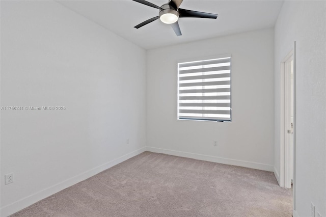 spare room with baseboards, light colored carpet, and a ceiling fan