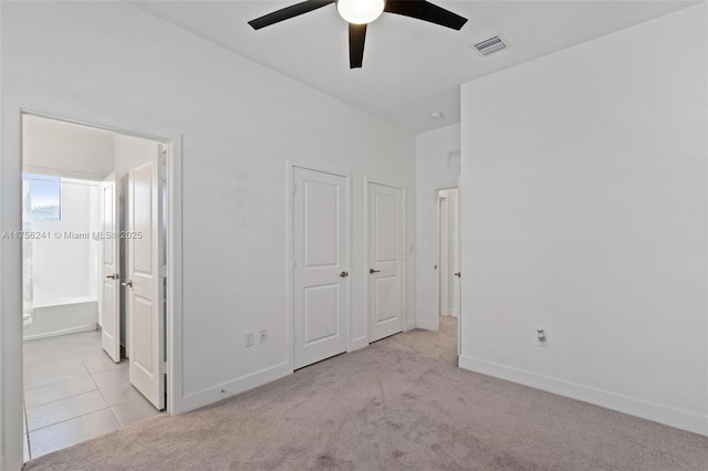 unfurnished bedroom with tile patterned floors, visible vents, baseboards, and carpet