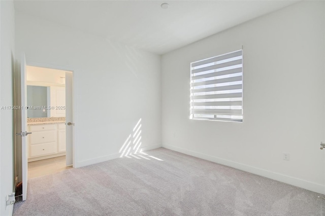 empty room with baseboards and light colored carpet