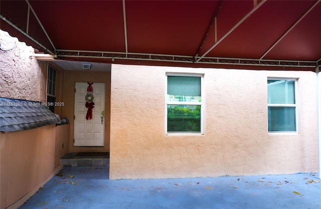 view of exterior entry with stucco siding