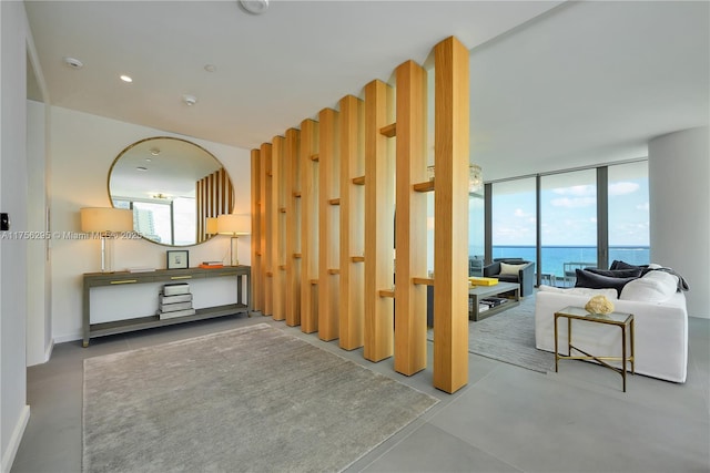 living room with recessed lighting, plenty of natural light, finished concrete floors, and floor to ceiling windows