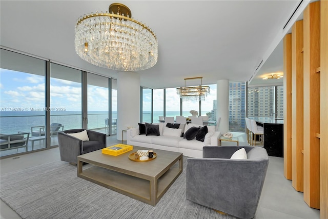 living area with a water view, a chandelier, and a wall of windows