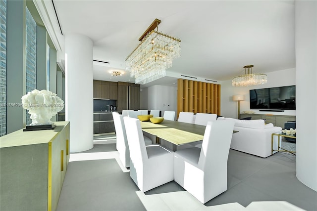 dining space featuring a chandelier and concrete floors