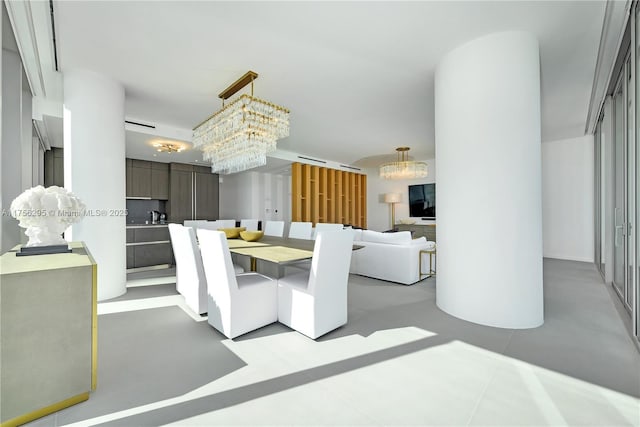 dining room with a chandelier and finished concrete flooring