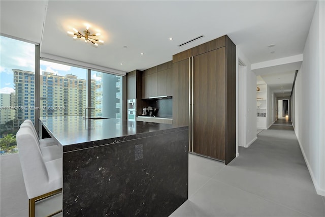 kitchen featuring concrete flooring, visible vents, baseboards, a view of city, and modern cabinets