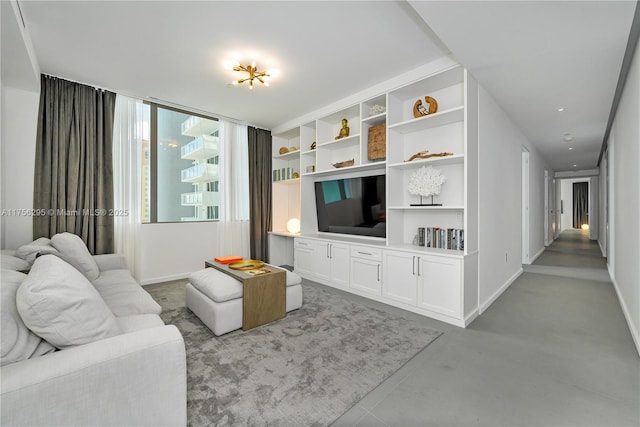 living room featuring concrete flooring and baseboards