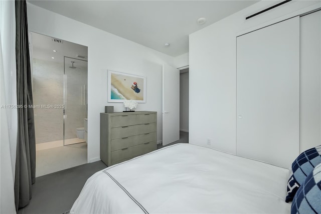 bedroom featuring ensuite bathroom, concrete floors, a closet, and visible vents