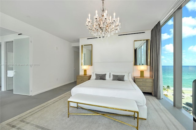 bedroom featuring concrete flooring, floor to ceiling windows, a water view, and baseboards