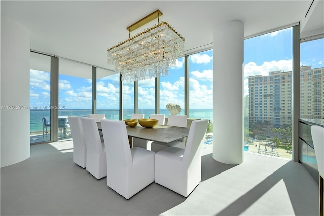 dining space with floor to ceiling windows, plenty of natural light, a water view, and an inviting chandelier