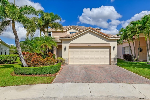 mediterranean / spanish-style home with stone siding, decorative driveway, a tiled roof, and stucco siding