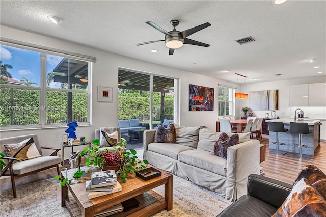4471 Foxtail Ln, Weston, FL 33331 - living room with light wood finished floors, a textured ceiling, visible vents, ceiling fan, and recessed lighting